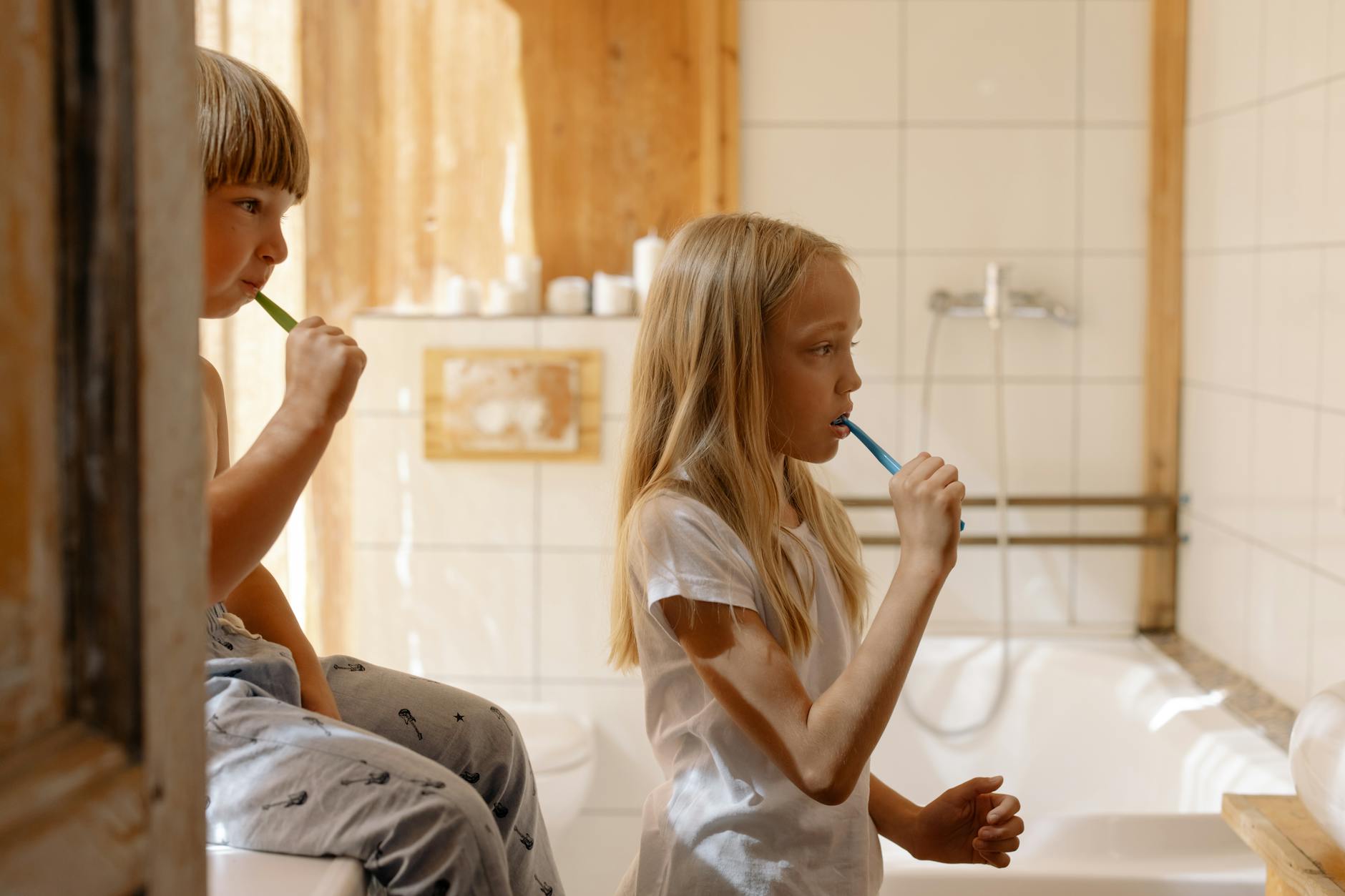 brother and sister brushing their teeth