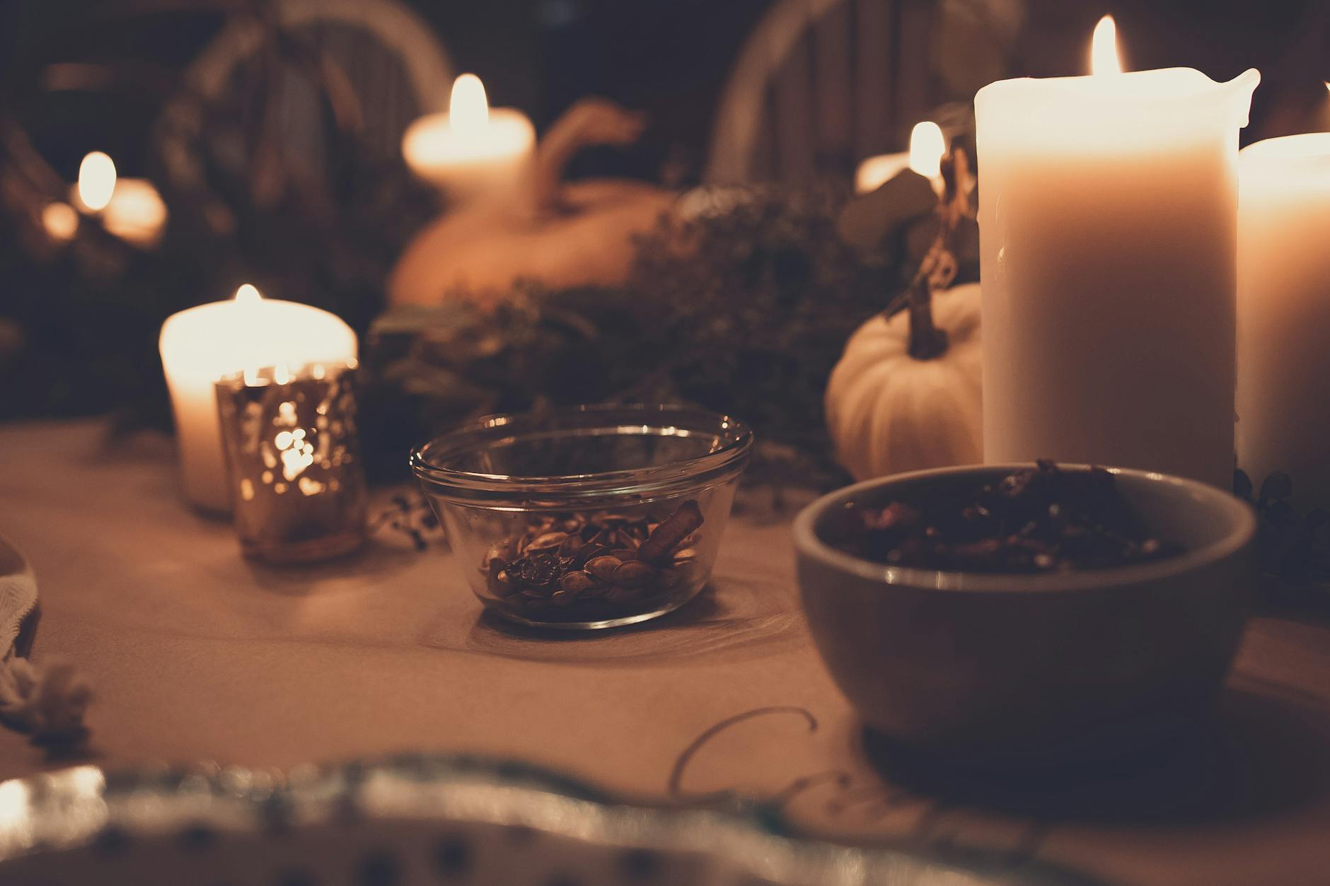pillar candles beside bowls on table