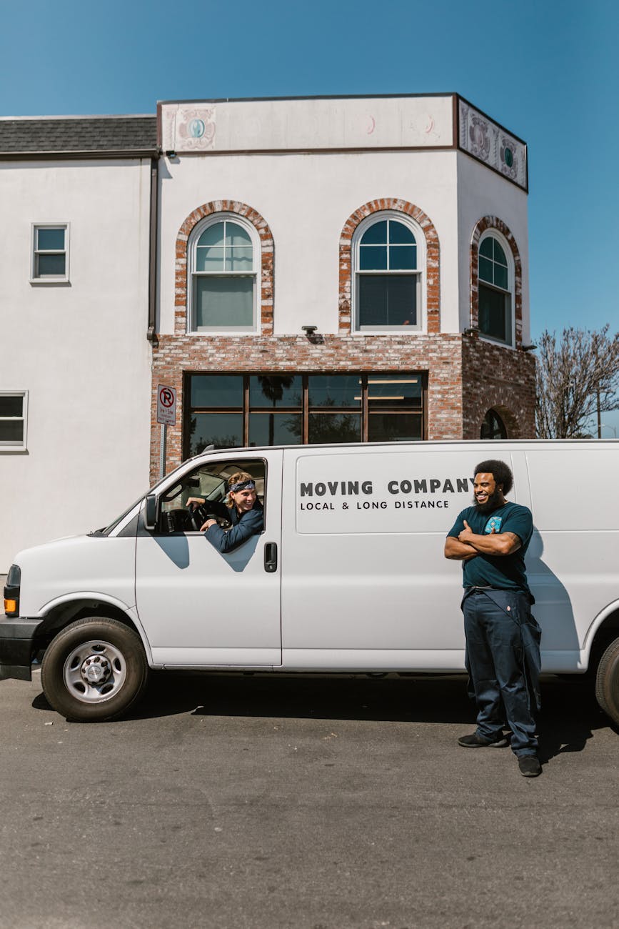 man in blue long sleeve shirt and blue denim jeans standing beside white van
