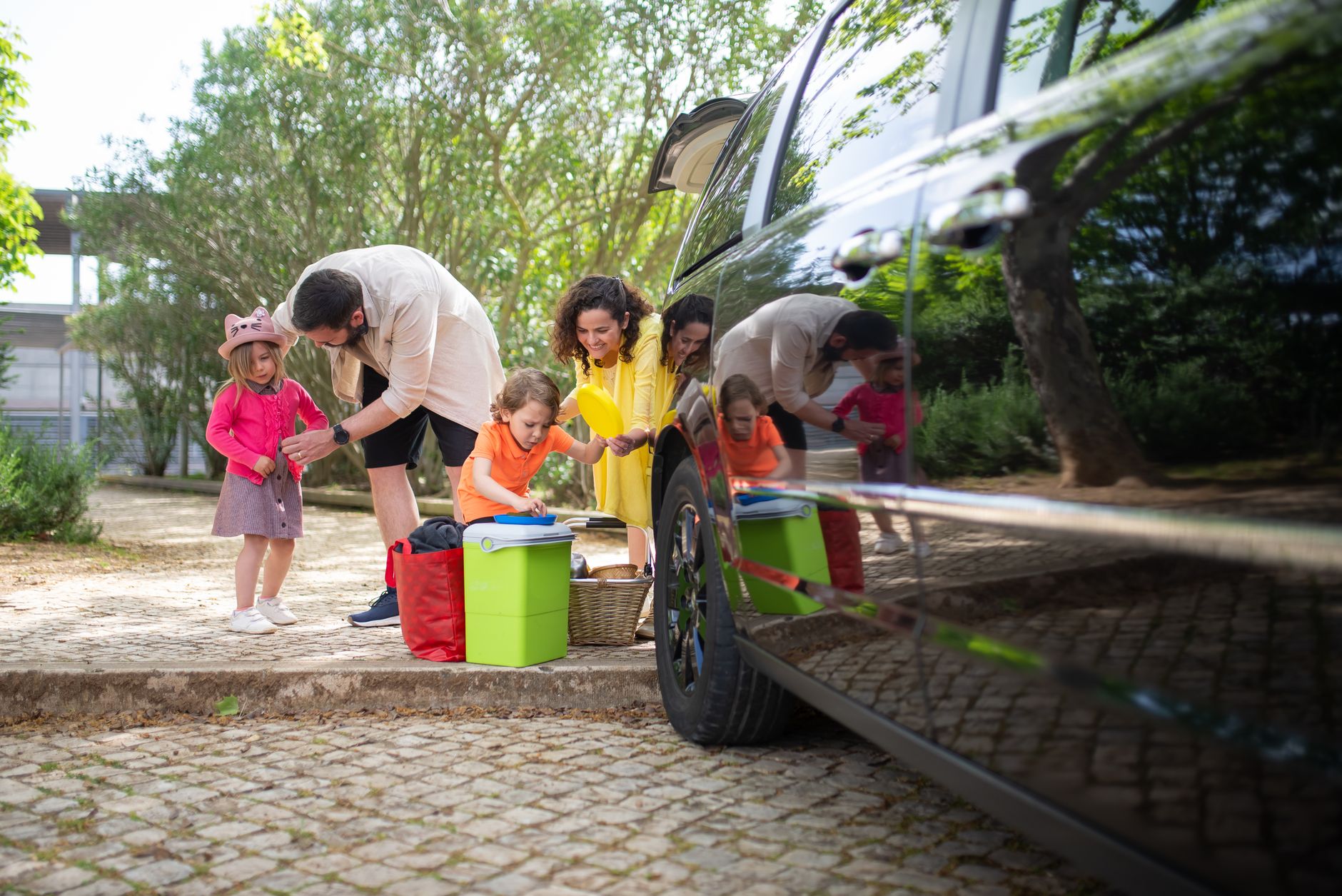 a family putting out the things from the compartment of a car