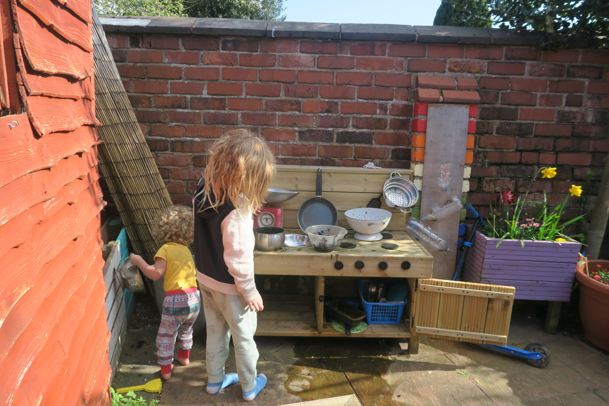 two brothers playing in the mud kitchen