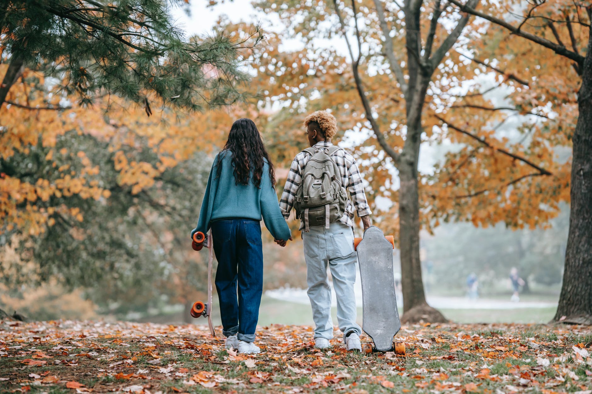 couple standing on brown leaves covered ground