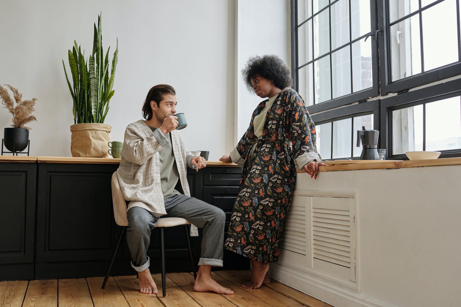 woman looking at a man sitting and having coffee