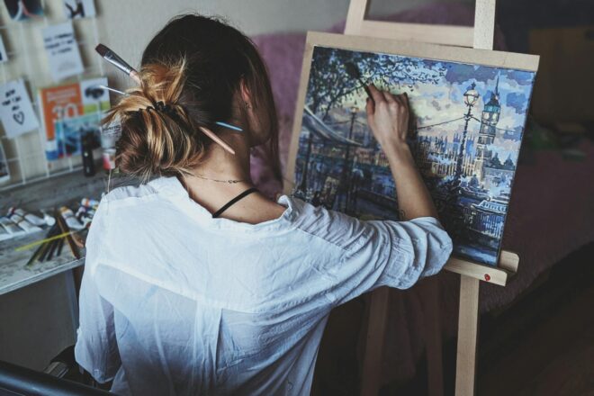 photo of woman in front of painting