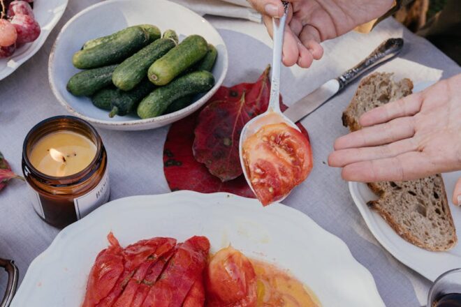 hand holding tomato on spoon