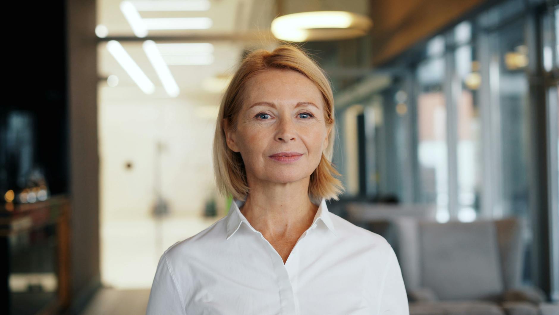 a woman in a white shirt standing in an office