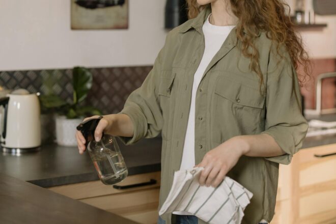 woman in gray coat holding clear glass mug