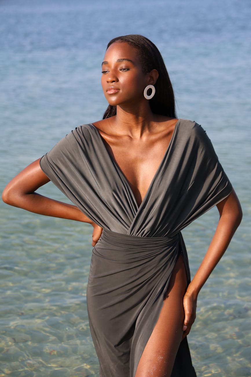 young elegant woman in a dress posing by the water